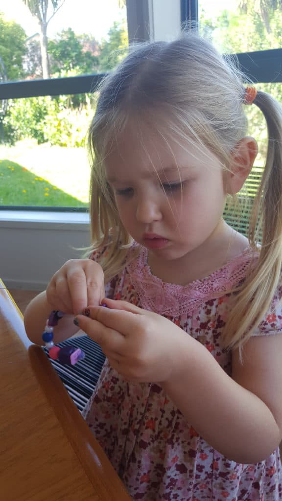 Child making a beaded candy cane